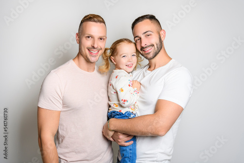 Two man couple with adopted child girl on white background