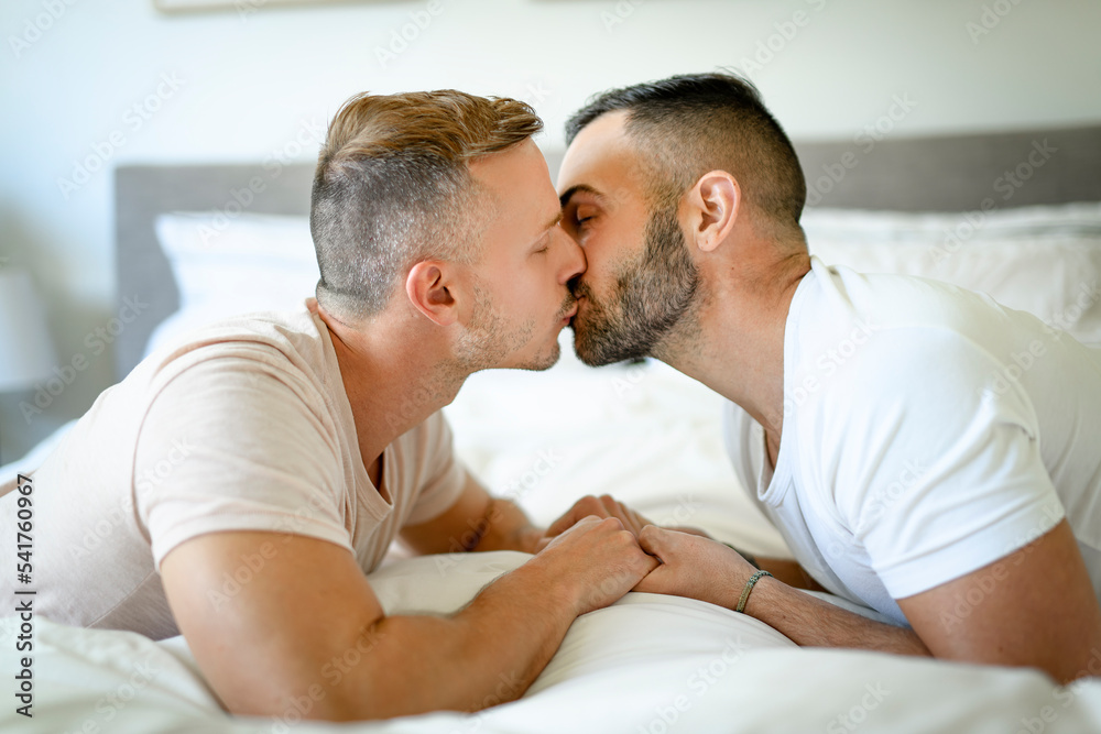 Two men couple in bed on a beautiful white bedroom Two men couple in bed on a beautiful white bedroom