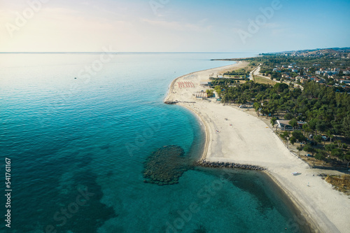Aerial view of a beautiful coastline with sandy beach, turquoise sea, lidos and lush parks in Isca sullo Ionio, Calabria, Italy. photo