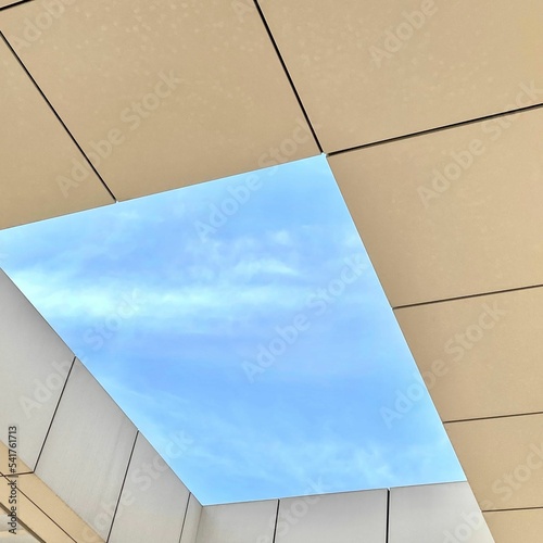 Foto Low angle shot of a skylight window in a ceiling with a view of a blue sky