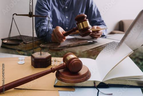 Business and lawyers discussing contract papers with brass scale on desk in office. Law, legal services, advice, justice and law concept picture with film grain effect