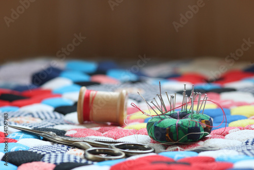 Quilting supplies on a colorful hexagon mosaic patterned quilt. The creative quilter. 