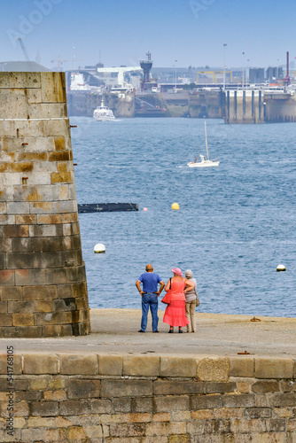 3 personnes contemplant le port de Saint Malo et la mer