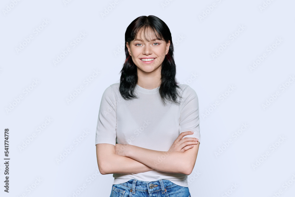 Portrait of positive young female with arms crossed over white background Portrait of positive young female with arms crossed over white background