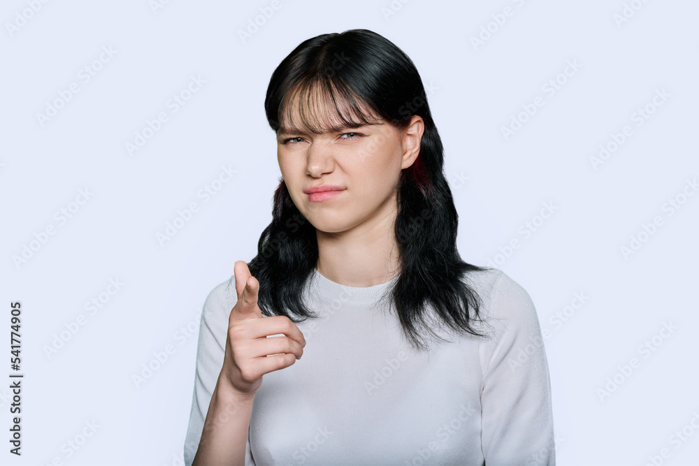 Young woman making grimace, showing trouble, on white background Young woman making grimace, showing trouble, on white background