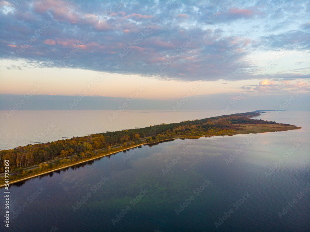 drone view of a colourful autumn sunset over the hel peninsula, the baltic sea and the gulf of puck; colourful autumn leaves on the trees