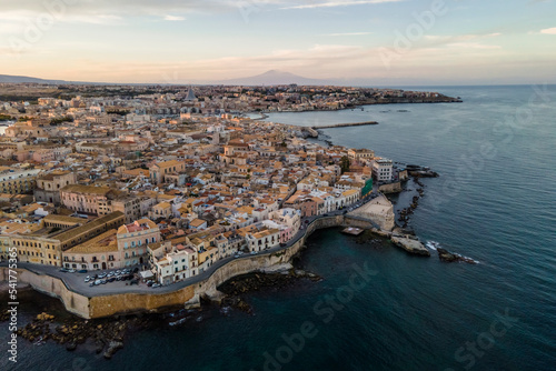Aerial view of Ortigia Island with Mount Etna in background at sunset in Syracuse, Sicily, Italy. photo