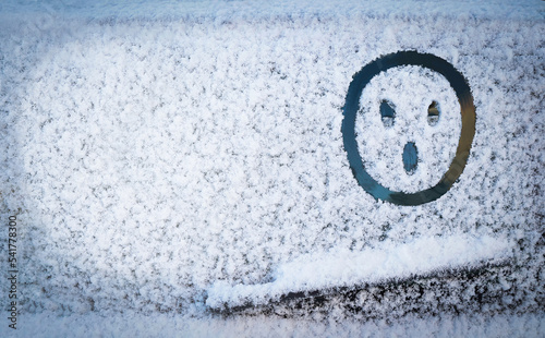Painted on snow above windshield wiper of car surprised, shocked, astonishment face (symbol). Change of weather, cooling, snowfall, dangers on road, winter, transport concept. Copy space. Empty place.