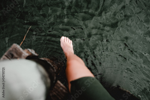 dangling feet on the footbridge over the river