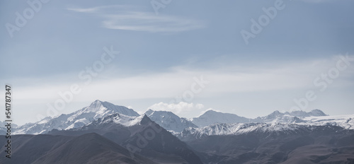 Panoramic view of mountain rock range  hills and peaks with snow and glaciers  monochrome landscape with cloudy sky