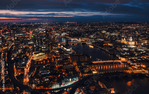 Aerial view of north east part of London, in evening. St Pauls Cathedral visible over river Thames