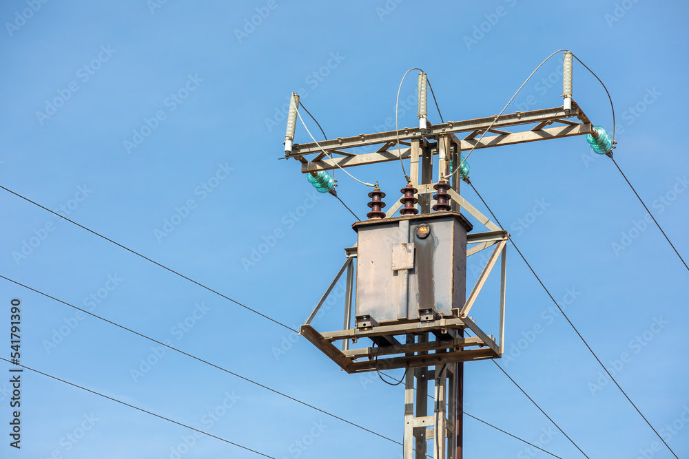 Power lines on background of blue sky - high voltage in the sky.