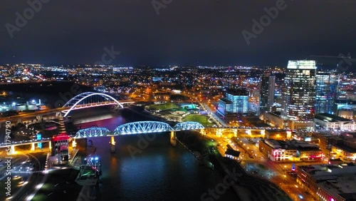 Aerial Shot Of Illuminated Famous Bridges In Illuminated City, Drone Flying Forward Over Cumberland River At Night - Nashville, Tennessee photo