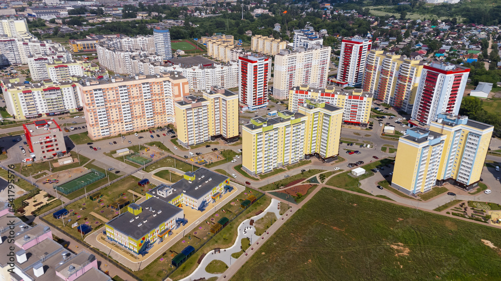 City, locality. Construction site, residential area on a sunny summer day. Apartment buildings, high-rise buildings. The view from the drone, from above.