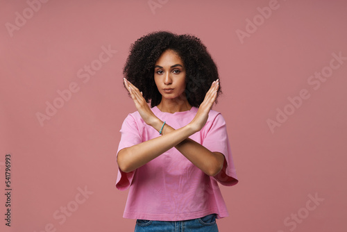 Portrait of young beautiful serious curly woman doing rejection gesture