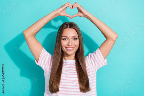 Photo of gorgeous pretty lovely girl straight hairdo dressed striped t-shirt hold arms above head isolated on teal color background