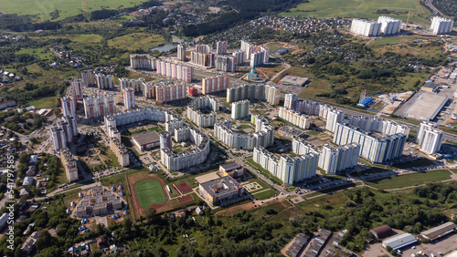 City, locality. Construction site, residential area on a sunny summer day. Apartment buildings, high-rise buildings. The view from the drone, from above.