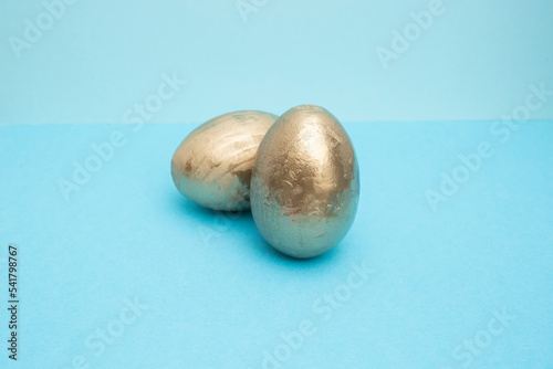 2 golden eggs on blue background