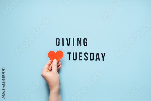 Giving Tuesday, Give, Help, Donation, Support, Volunteer concept with red heart in female hands and text Giving Tuesday on blue background. Its time to give
