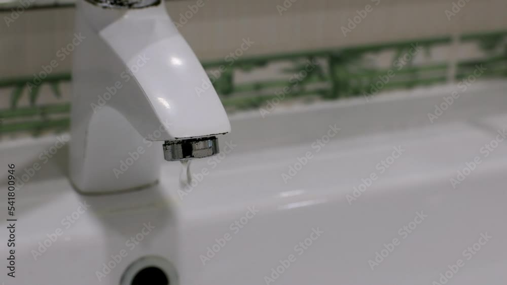 Bathroom. Dripping water from a white faucet. Water leakage concept. Stock Video | Adobe Stock