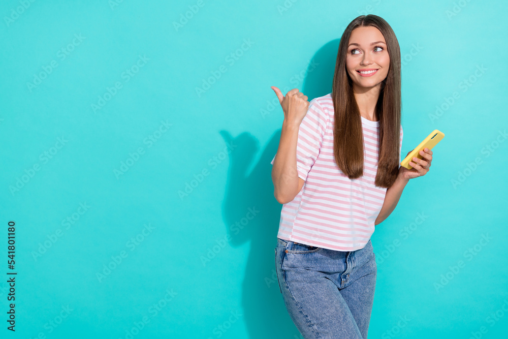 Photo of adorable positive nice girl with straight hairdo striped t-shirt directing look empty space isolated on teal color background Photo of adorable positive nice girl with straight hairdo striped t-shirt directing look empty space isolated on teal color background