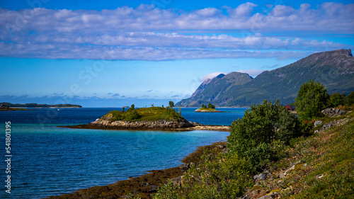 panorama of the landscape of the senja island, northern norway, small colourful houses on the seashore under huge rocks and cliffs, paradise beaches in rocky fjords