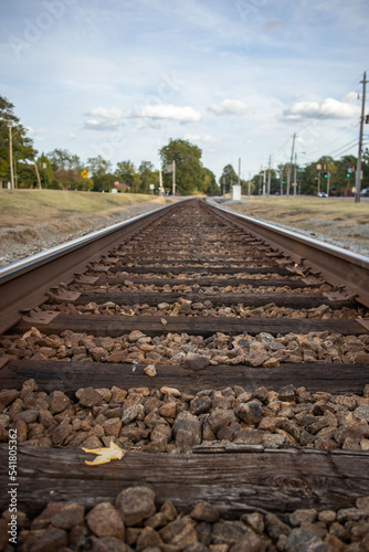 Long Railroad Train Tracks with Buildings and a Pretty Sky in the background