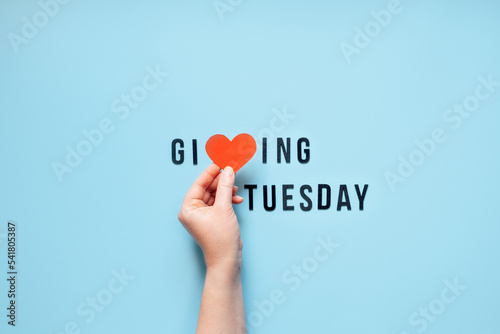 Giving Tuesday, Give, Help, Donation, Support, Volunteer concept with red heart in female hands and text Giving Tuesday on blue background. Its time to give
