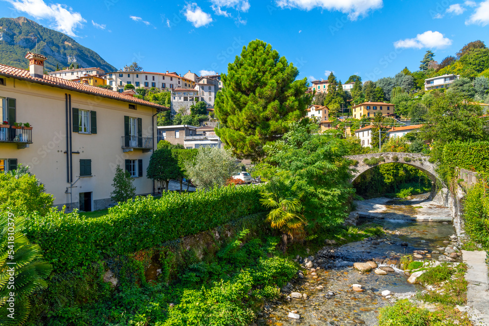 A small stream or river runs through the old town center of the lakefront town of Menaggio, Italy, on the shores of Lake Como.
