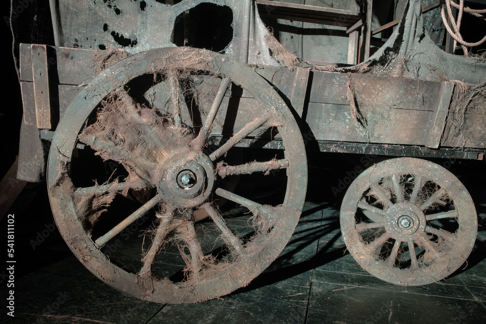 A wheels of the vintage wooden wagon on the dark background