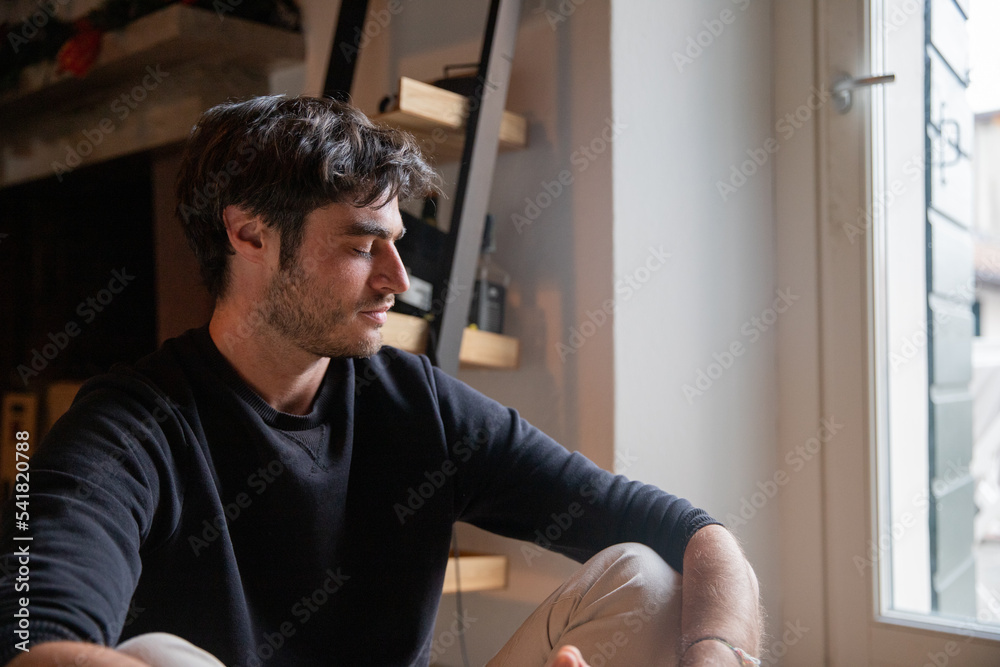 Concentrated man in his 30s seated on the floor with eyes closed. Meditation concept. Concentrated man in his 30s seated on the floor with eyes closed. Meditation concept.