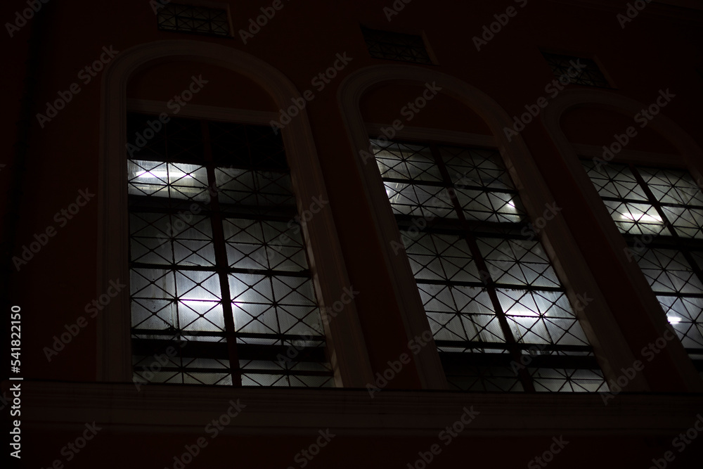 Windows at night. Light in windows in evening. Building outside in dark.
