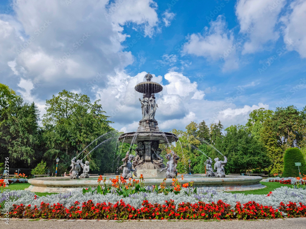 Fototapeta premium Beautiful fountain in the city park Stadtpark, a green island in the middle of the city center of Graz, Styria region, Austria. Selective focus