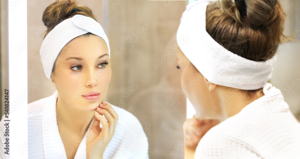 woman looking in the mirror in the bathroom and taking care of her skin.Applying the cream .Magic anti-aging cream. woman looking in the mirror in the bathroom and taking care of her skin.Applying the cream .Magic anti-aging cream.