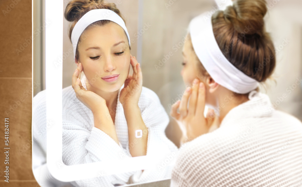 woman looking in the mirror in the bathroom and taking care of her skin.Applying the cream .Magic anti-aging cream. woman looking in the mirror in the bathroom and taking care of her skin.Applying the cream .Magic anti-aging cream.