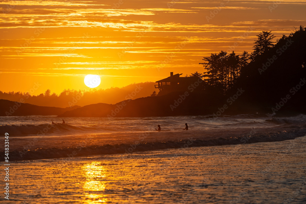Sunset by Chesterman Beach with surfers in the Pacific Ocean, Tofino, British Columbia, Canada. Sunset by Chesterman Beach with surfers in the Pacific Ocean, Tofino, British Columbia, Canada.