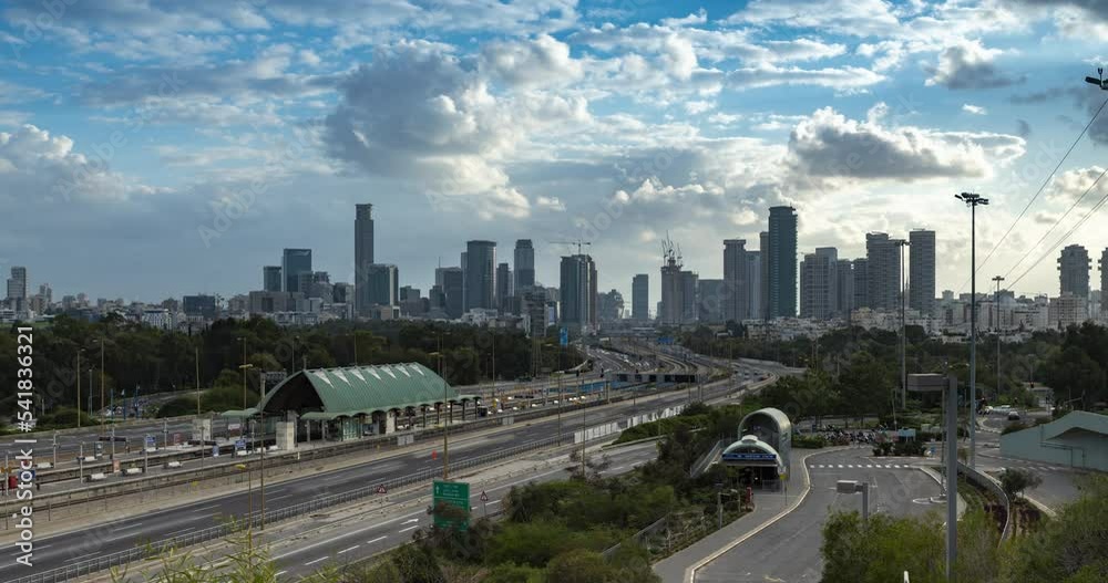 Time lapse of cars driving via ayalon road, in front of the cityscape of ramat gan and Tel Aviv cities with moving blue cloudy skies, Israel Time lapse of cars driving via ayalon road, in front of the cityscape of ramat gan and Tel Aviv cities with moving blue cloudy skies, Israel