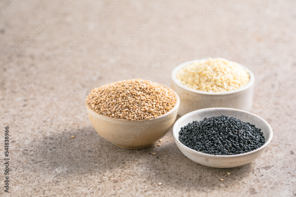 Set with different sesame seeds on stone background. top view. Set with different sesame seeds on stone background. top view.