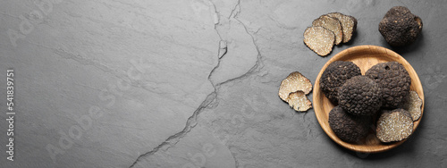 Obraz na płótnie Black truffles on grey table, flat lay with space for text