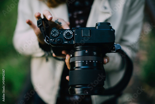 Woman photographer, holding and reviewing mirrorless camera images 