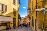 A colorful street of shops and sidewalk cafes in the historic center of the lakefront town of Menaggio, Italy, on the shores of Lake Como.