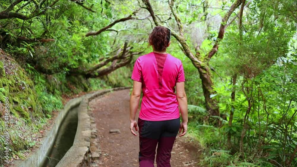 following a Caucasian girl walking in the lush and relaxing jungle following a Caucasian girl walking in the lush and relaxing jungle