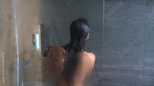 Attractive young woman washing and dancing in the shower