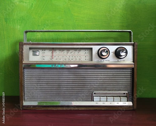 old transistor radio on wooden table green wall background