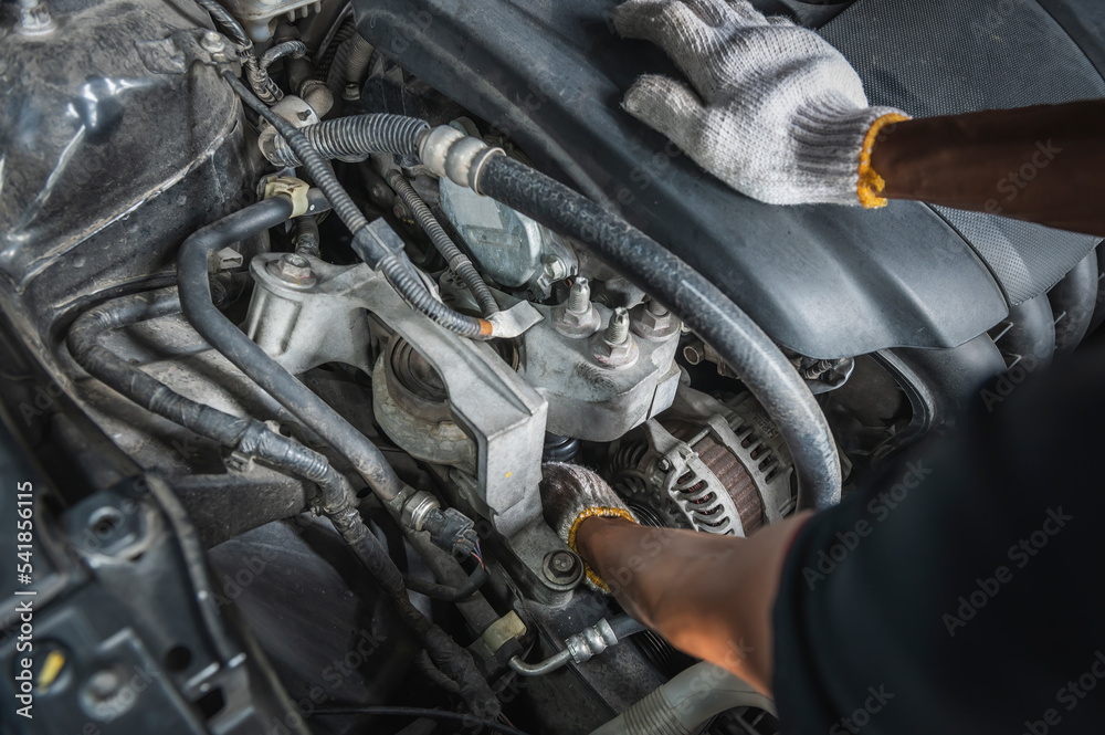Fototapeta premium Auto mechanic checking alternators on the engine.