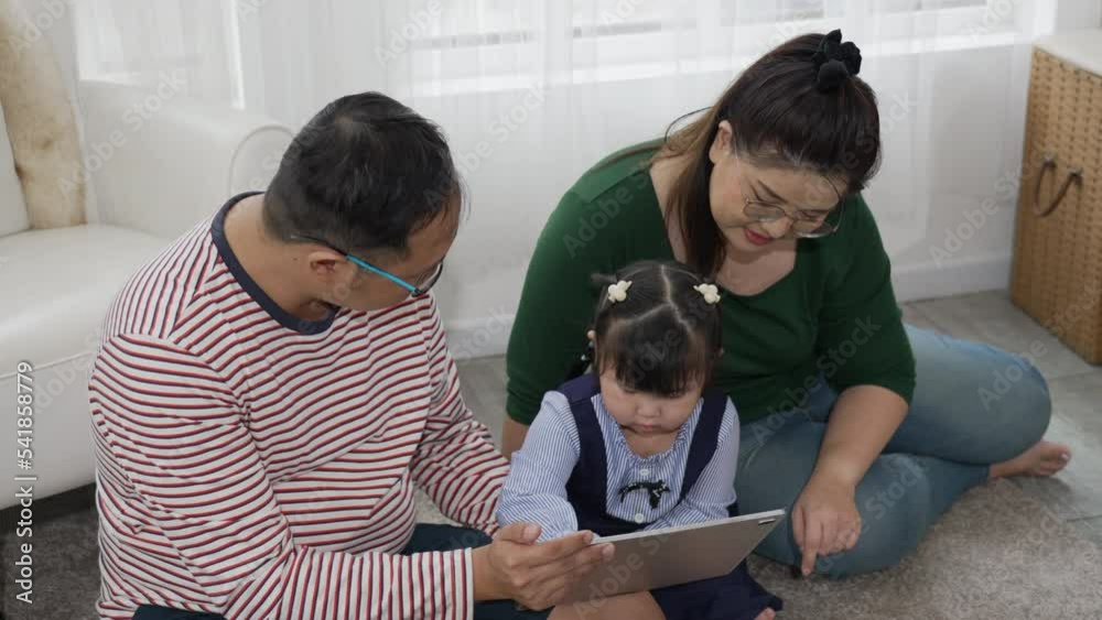 Asian Family Watching Cartoon From Computer Together at Home Asian Family Watching Cartoon From Computer Together at Home
