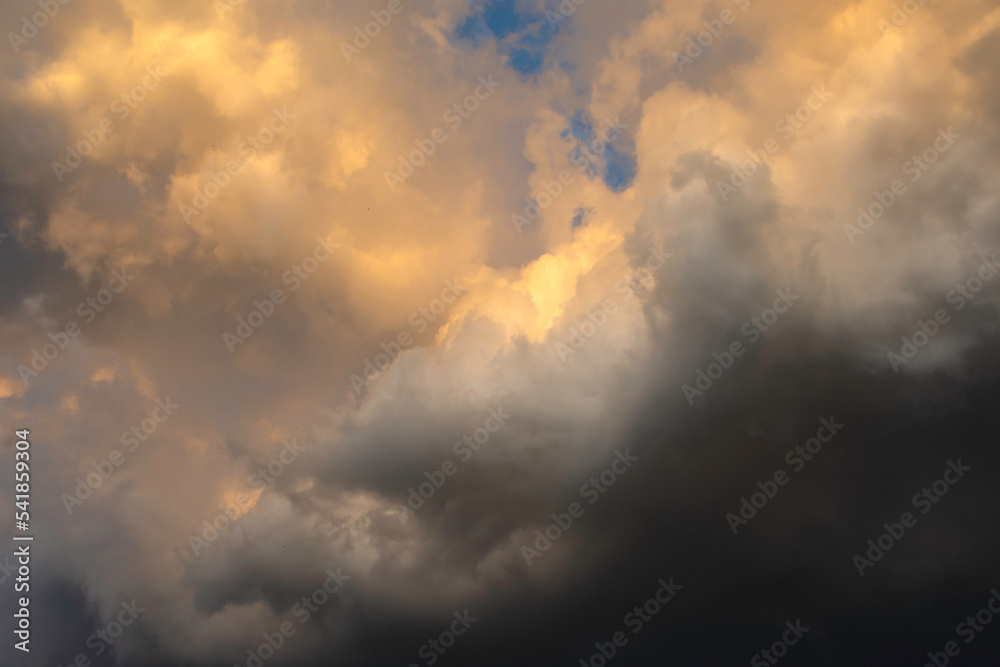 Rain clouds form as the sun is about to set. Stock Photo | Adobe Stock