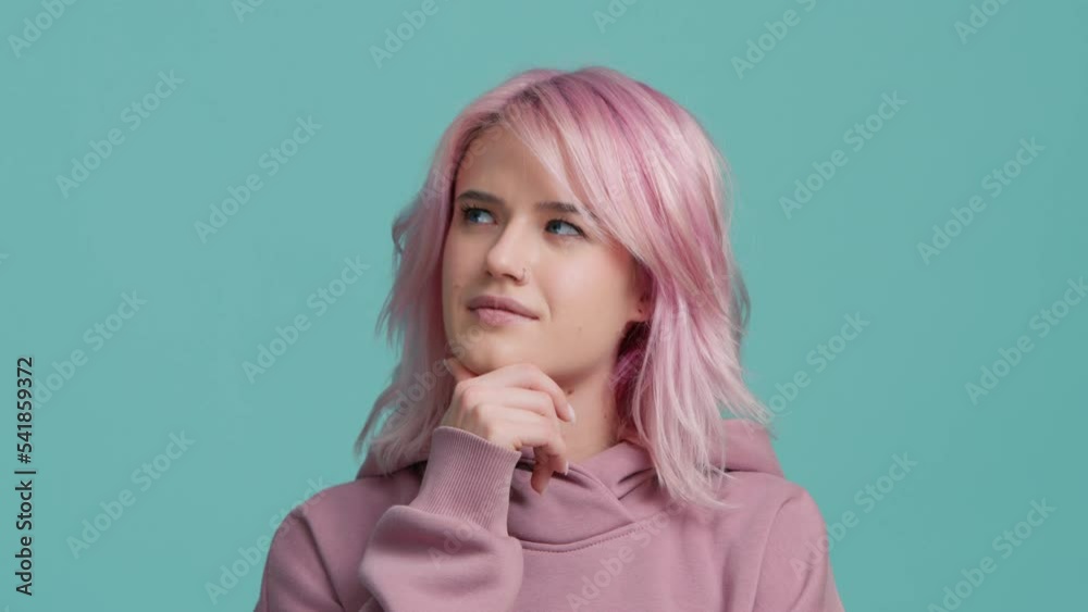 Great idea gesture. Cute hipster girl with pink hair raised index finger up came up with great cool fresh idea, dyed hair model looking at camera isolated on blue background, understanding concept Great idea gesture. Cute hipster girl with pink hair raised index finger up came up with great cool fresh idea, dyed hair model looking at camera isolated on blue background, understanding concept