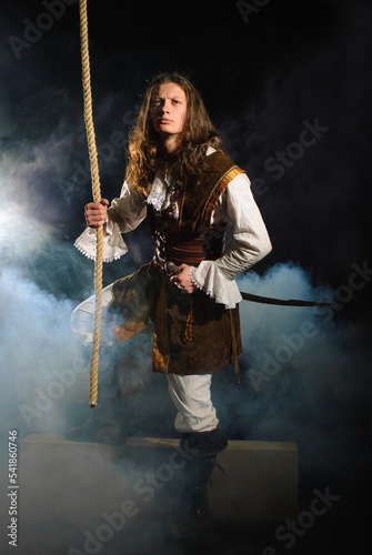Young pirate captain with gun holding onto rope