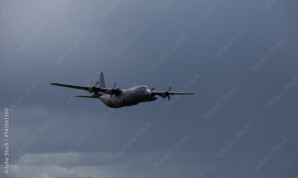 military transport aircraft at low altitude with dark clouds in the background military transport aircraft at low altitude with dark clouds in the background